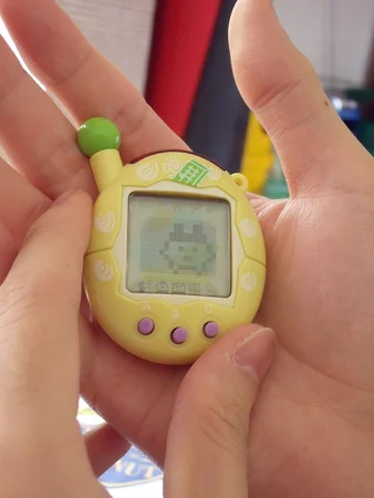 Person holding a Tamagotchi in their hands